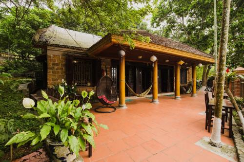 ein Gebäude mit einer Veranda mit Schaukel in der Unterkunft Bavi Homestead in Ba Vì