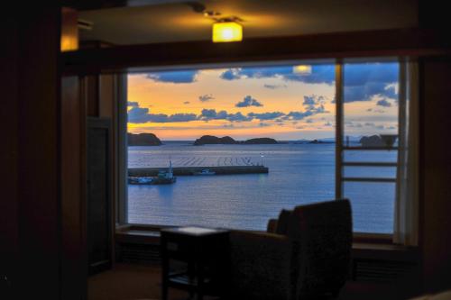 a window view of the ocean with a boat in the water at IKI RETREAT by Onko Chishin in Iki