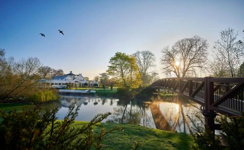 a bridge over a river with a house and a bridge at Monkey Island Estate - Small Luxury Hotels of the World in Bray