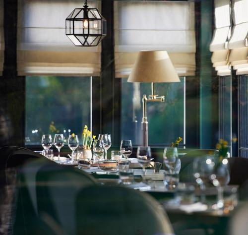 a table with wine glasses on it with a lamp at Monkey Island Estate - Small Luxury Hotels of the World in Bray