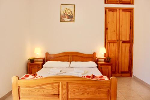 a bedroom with a wooden bed with two pillows at Nir Apartments Budva in Budva