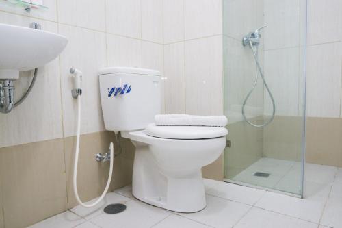a bathroom with a toilet and a shower at City View Studio Apartment at Tamansari La Grande By Travelio in Bandung