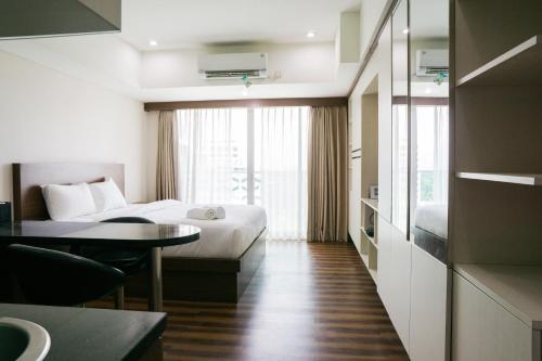 a hotel room with a bed and a table at City View Studio Apartment at Tamansari La Grande By Travelio in Bandung