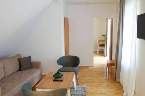 a living room with a couch and a table and chairs at Hotel Altes Fährhaus in Berlin