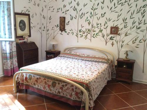 1 dormitorio con 1 cama y papel pintado con motivos florales en Villa Le Palme, en Rosa Marina
