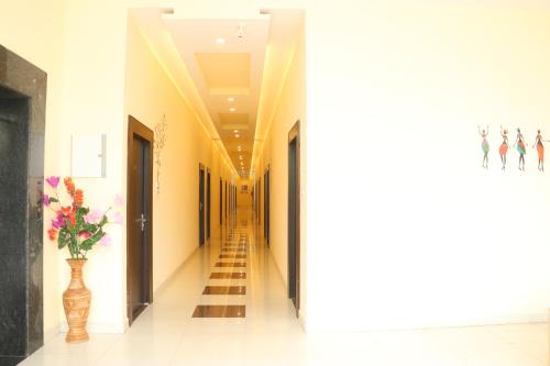 a hallway with a vase of flowers in a room at GenX Mirzapur in Mirzāpur