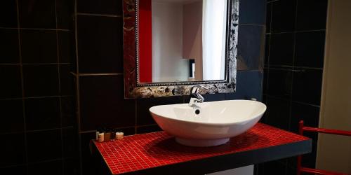 ein Badezimmer mit einem weißen Waschbecken und einem Spiegel in der Unterkunft 21 Kingfisher Guesthouse in Johannesburg