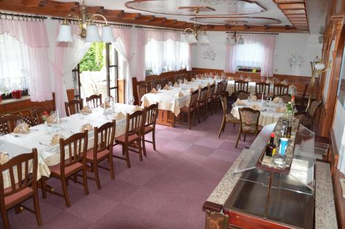 a dining room with white tables and chairs at Penzion Livada in Kranjska Gora
