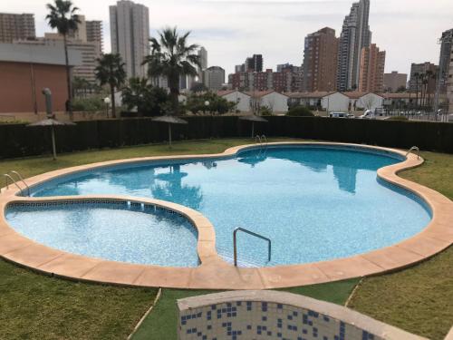 a large swimming pool with a city skyline in the background at Parc Loix apartment in Benidorm