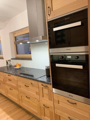 a kitchen with wooden cabinets and a microwave at Villa Stiegl in Steindorf am Ossiacher See