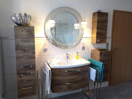 ein Bad mit einem Waschbecken und einem Spiegel in der Unterkunft Ferienwohnung Libelle in Burhave