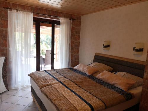 ein Schlafzimmer mit einem großen Bett und einem großen Fenster in der Unterkunft Ferienwohnung Libelle in Burhave