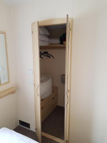 a closet with a door open to a bedroom at Caravan Willerby Rio in Looe