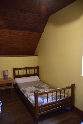 una camera con letto e soffitto in legno di grange typique du quercy a La Bécade