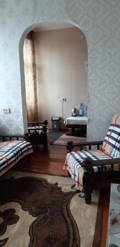 a living room with two beds and a mirror at Nikoloz Guesthouse in Stepantsminda