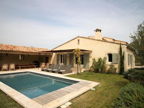 a villa with a swimming pool in front of a house at Grandeur Villa in Eygali res with Pool in Eygalières