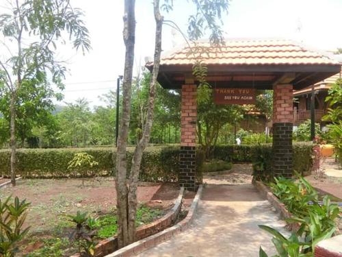 a brick pavilion with a sign in a garden at Greenhouse Retreat in Sen Monorom