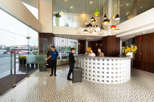 two men standing in front of a bar in a building at Grand Citiview Da Nang Hotel in Da Nang