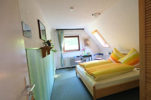 ein Schlafzimmer mit einem Bett mit gelber Bettwäsche und einem Fenster in der Unterkunft Frauenpension Arleta - Women only in Goslar