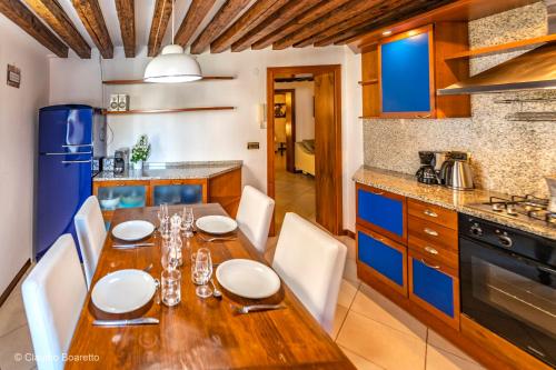 a kitchen with a wooden table and chairs and a kitchen with blue cabinets at PALAZZINA ADORATA - VeniseJeTaime in Venice