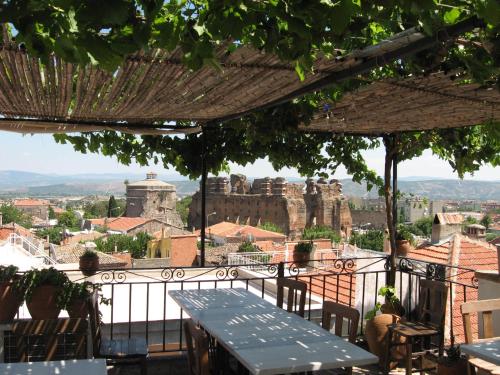 een tafel en stoelen op een balkon met uitzicht op de stad bij Odyssey Guest House in Bergama