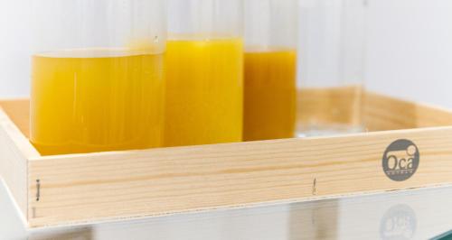 a wooden box with three glasses of orange juice at Oca Playa de Foz Hotel & Spa in Foz