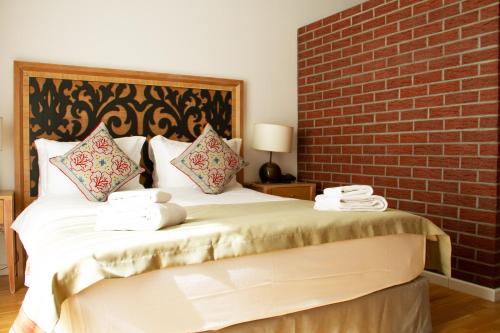a bedroom with a large bed with a brick wall at Hotel Altes Fährhaus in Berlin