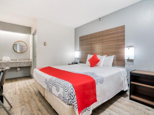 a hotel room with a large bed with a red blanket at Dallas Love Field Inn in Dallas