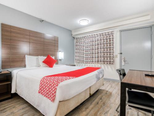 a hotel room with a large bed and a desk at Dallas Love Field Inn in Dallas