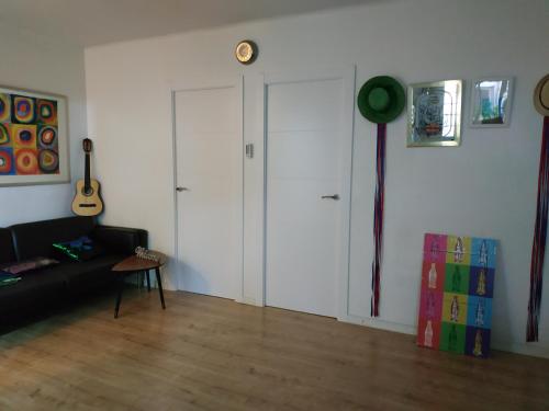 a living room with two white doors and a guitar at Apartment Barca 1 Camp Nou in Barcelona