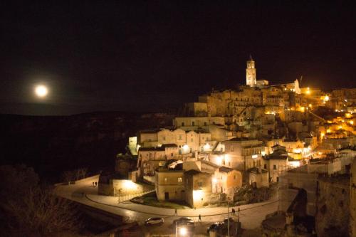 a city at night with a castle on a hill at I Tre Cardilli in Matera