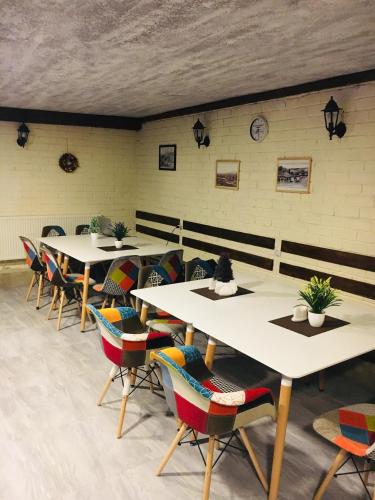 a row of tables in a room with colorful chairs at Hotel Terrace Rabath in Akhaltsikhe