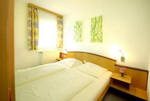een slaapkamer met een groot bed en een raam bij Familienhotel Reiterhof Runding in Runding