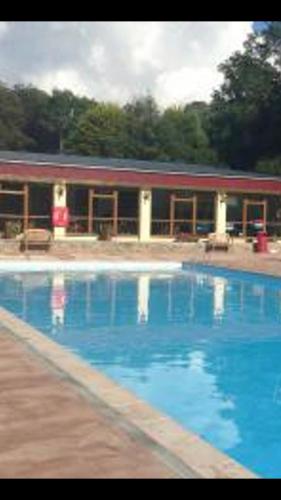 a large blue swimming pool with a building in the background at White Lodge in Caernarfon