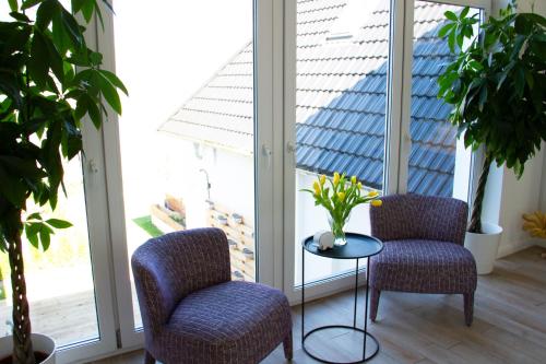 two chairs and a table in a room with windows at Hotel Altes Fährhaus in Berlin