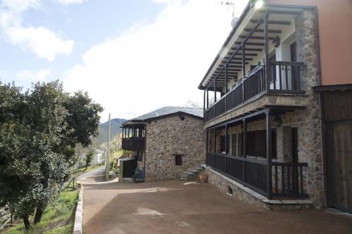 a building with a balcony on the side of it at O Palleiro do Pe do Forno in Orellán