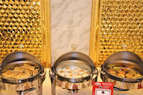 two pans of food on a shelf in a buffet at Hotel Uzbekistan in Urganch