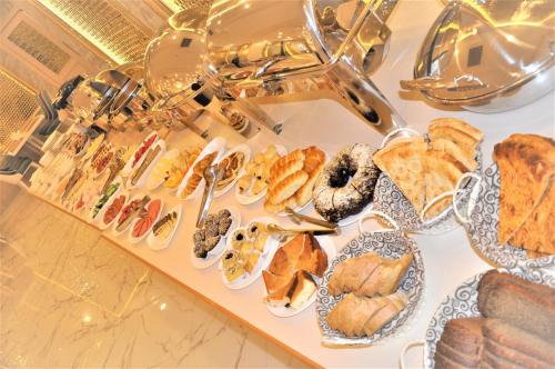 a table topped with lots of different types of pastries at Hotel Uzbekistan in Urganch