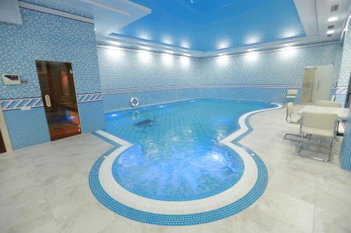 a large swimming pool in a blue room with at Hotel Uzbekistan in Urganch