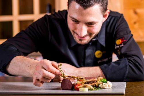 a man sitting at a table with a plate of food at Hotel Rommisa in Perca