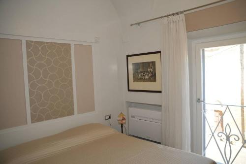 タルクイーニアにあるCamere con vista (Rooms with a view)のベッドルーム1室(ベッド1台付)、スライド式ガラスドアが備わります。