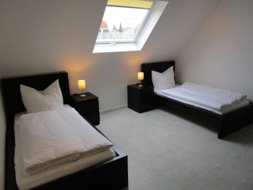 2 Betten in einem Zimmer mit 2 Lampen an Tischen in der Unterkunft Schicke Komfortwohnung zum Wohlfühlen in Merchweiler