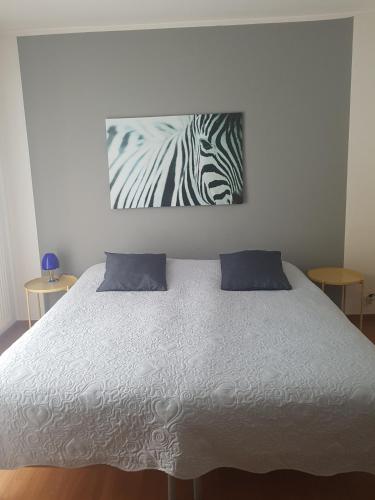 ルガノにあるHomestay Dodoのベッドルーム1室(シマウマの絵画が飾られたベッド1台付)
