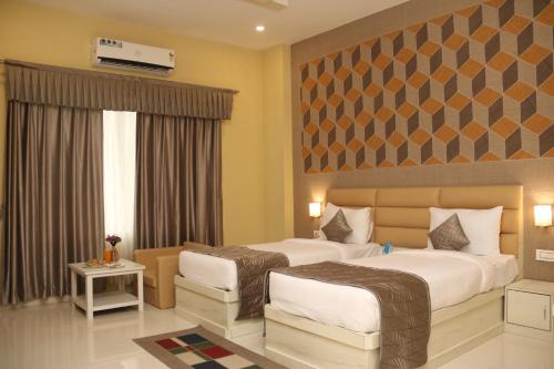 a hotel room with two beds and a tv at GenX Mirzapur in Mirzāpur