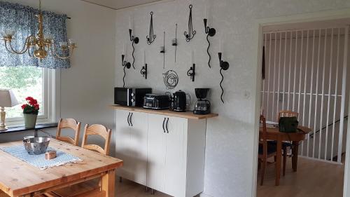 a kitchen with a table and utensils hanging on the wall at Lust Huset in Ambjörnarp
