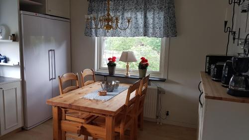 a kitchen with a wooden table and chairs and a window at Lust Huset in Ambjörnarp