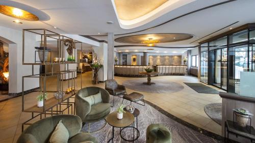 a lobby of a hotel with chairs and tables at aja Fürstenhaus am Achensee in Pertisau