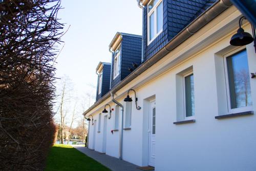 a row of white buildings with windows and a sidewalk at Hotel Altes Fährhaus in Berlin