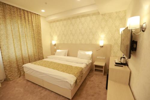 a hotel room with a bed and a television at Hotel Uzbekistan in Urganch