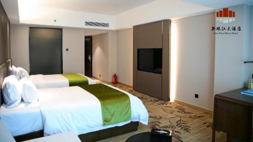 a hotel room with two beds and a flat screen tv at New Pearl River Hotel in Guangzhou